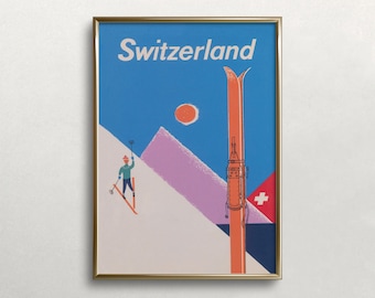 Puede incluir: Un póster de viaje enmarcado titulado Switzerland que muestra un cielo azul, un sol rojo y montañas moradas. Un esquiador con chaqueta verde azulado está en una pendiente blanca, mientras un esquí naranja grande destaca en primer plano con una bandera suiza.