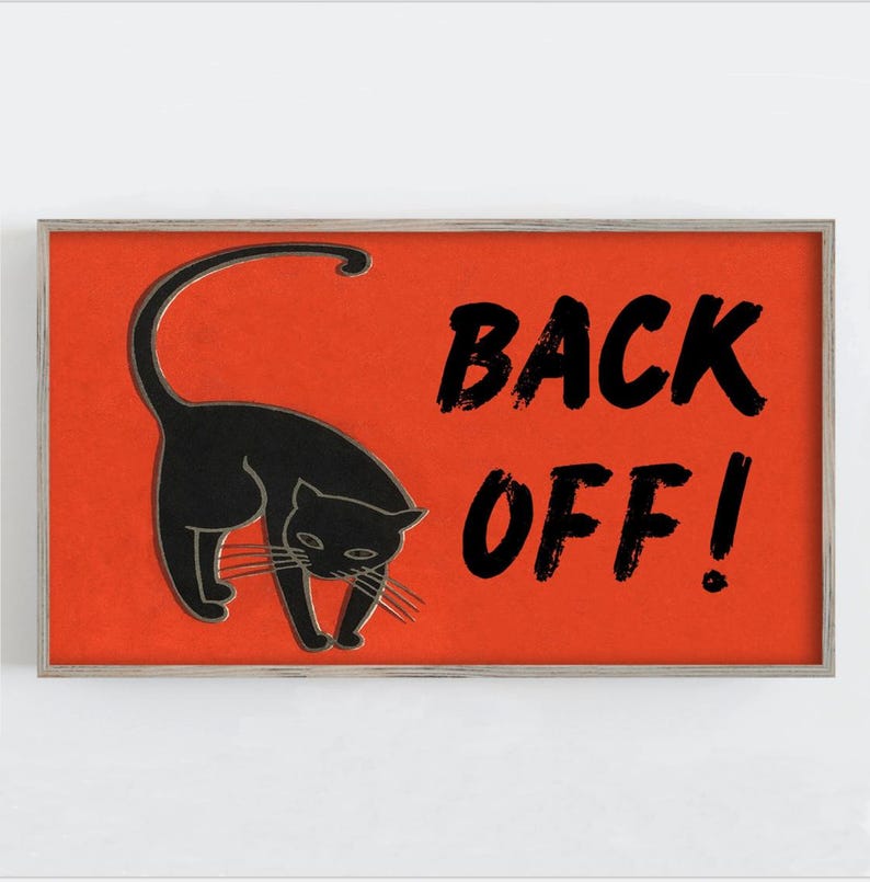 May include: A framed print featuring a black cat silhouette on a vibrant orange background. Bold black text reads "BACK OFF!" The artwork has a minimalist design, perfect for Halloween or cat lovers.
