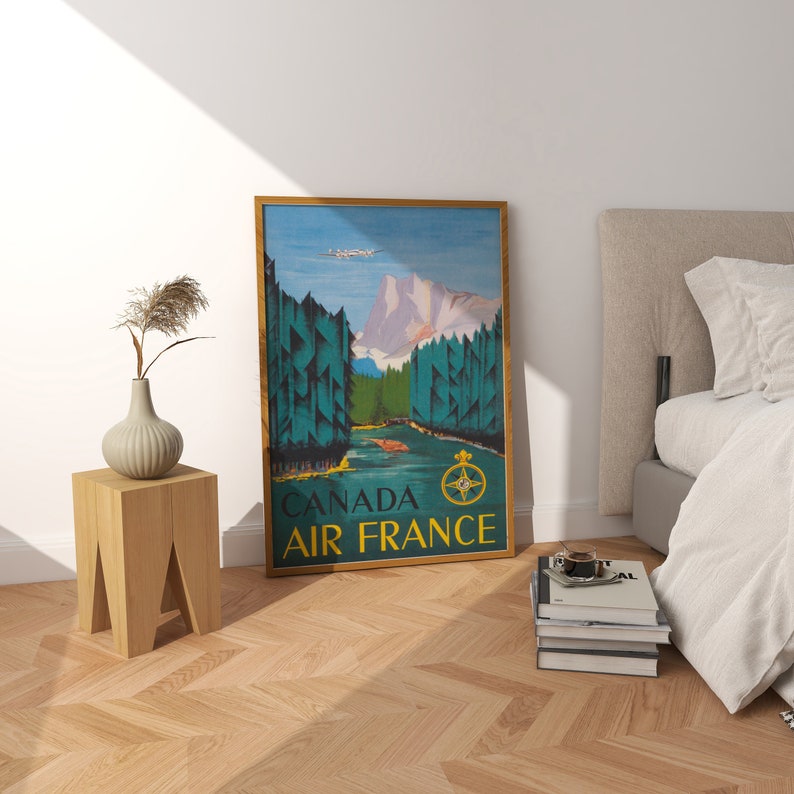 May include: A vintage travel poster for Air France featuring a scenic landscape of mountains, trees, and a river. The poster is framed in gold and has the text "Canada Air France" at the bottom.