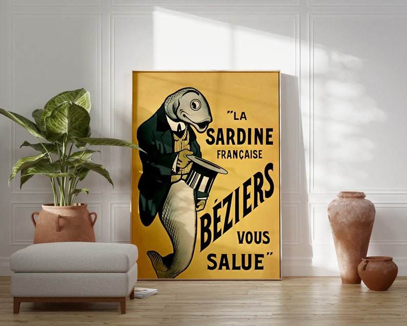 K&ouml;nnte beinhalten: Ein gerahmtes vertikales Poster mit gelbem Hintergrund, das einen anthropomorphen Fisch in einer dunklen Jacke und gestreiften Weste zeigt, der einen Zylinder h&auml;lt. Der Text lautet: LA SARDINE FRAN&Ccedil;AISE B&Eacute;ZIERS VOUS SALUE. Die Illustration ist im Vintage-Stil.