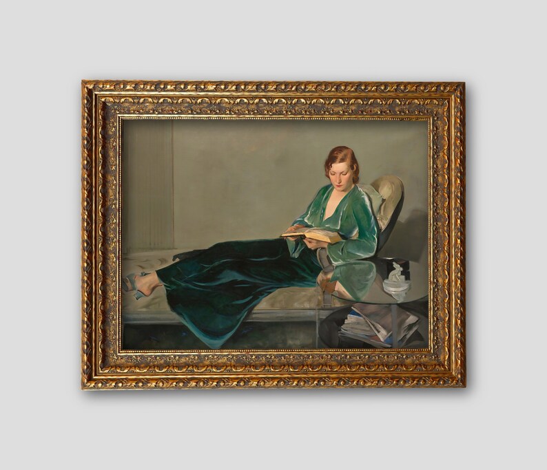 May include: A painting of a woman in a green velvet robe sitting on a couch and reading a book. The woman is wearing a green velvet robe and has her hair pulled back. She is sitting on a couch with a white cushion and a glass table in front of her. The painting is framed in a gold frame.