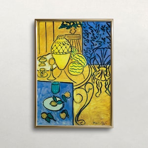 May include: A still life painting by Henri Matisse featuring a yellow vase with a geometric pattern, lemons, and a blue table with a glass of water. The painting is framed in gold and has the artist's signature "MATISSE" in the bottom right corner.