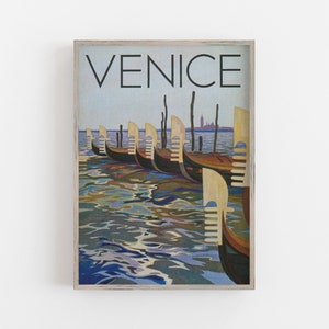 May include: A framed print featuring a vintage travel poster of Venice. The artwork depicts several gondolas docked on the water, with the word "VENICE" at the top. The water reflects the sky and boats.