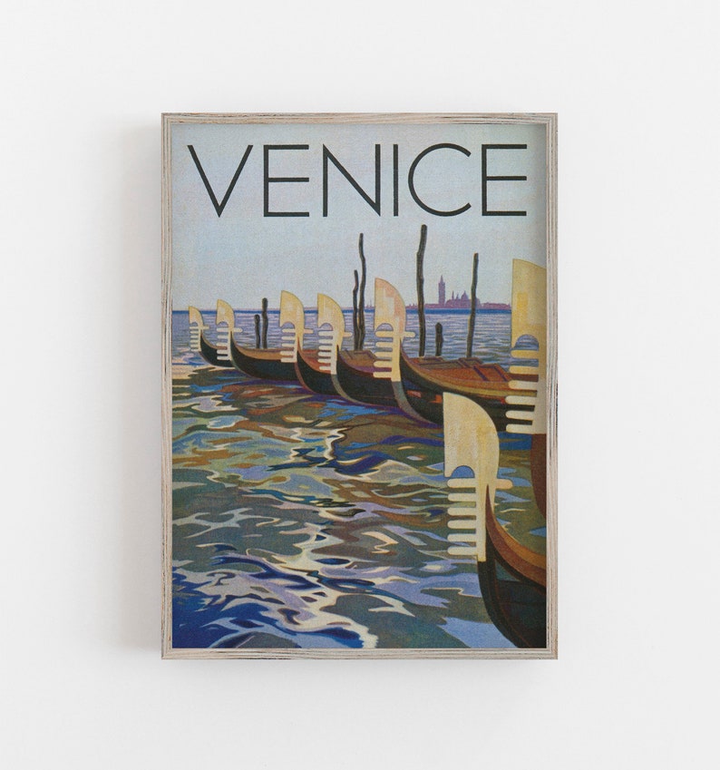 May include: A framed print featuring a vintage travel poster of Venice. The artwork depicts several gondolas docked on the water, with the word "VENICE" at the top. The water reflects the sky and boats.