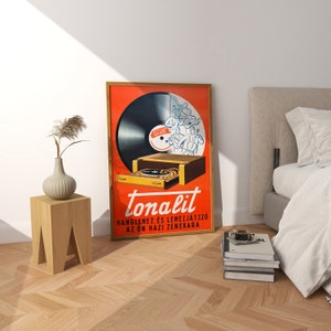 May include: A vintage advertisement for "tonalit" a record player and radio. The ad features a red background with a black vinyl record, a record player, and a group of musicians playing instruments. The text reads "tonalit" "hangleme and lemezjatszo az on hazi zenekara".