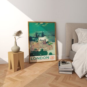 May include: A vintage travel poster advertising travel to London, England. The poster features a green background with a view of Tower Bridge and the River Thames. The text on the poster reads "London GWR Enquire for Cheap Ticket Facilities".