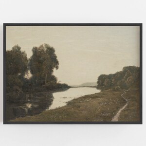 May include: A framed landscape painting featuring a river winding through a serene, muted-color scene. The artwork depicts trees along the riverbanks and a path on the right, all under a soft, overcast sky. The frame is black.