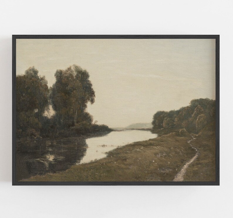 May include: A framed landscape painting featuring a river winding through a serene, muted-color scene. The artwork depicts trees along the riverbanks and a path on the right, all under a soft, overcast sky. The frame is black.