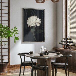 May include: Interior shot of a dining room with a round wooden table and black chairs. A framed floral print hangs on the wall. Wooden pendant lights and a Japanese-style screen add to the decor. A potted plant is also visible.