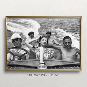 May include: Black and white framed print of a vintage photograph. The image shows five people on a speedboat, with the driver wearing sunglasses and a hat. The text "VIBRANT VINTAGE PRINTS" is at the bottom.