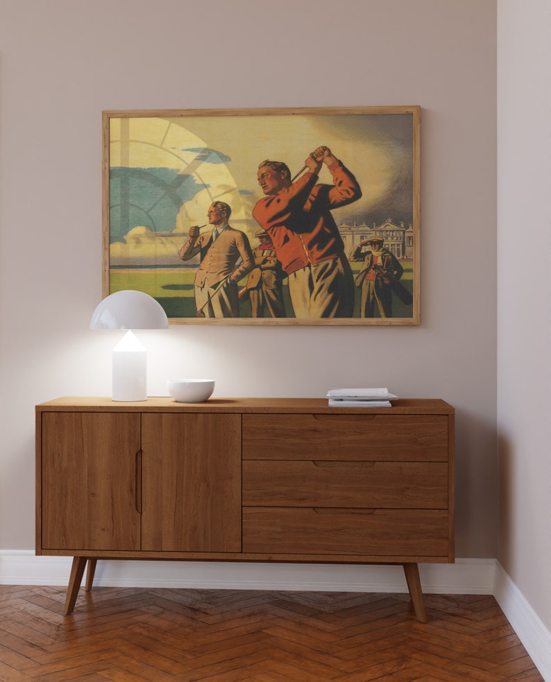 Pu&ograve; includere: Un poster vintage incorniciato che raffigura un gruppo di uomini che giocano a golf su un campo verde. Il poster ha una cornice marrone chiaro e presenta un cielo azzurro con nuvole bianche. Gli uomini indossano abiti degli anni '20, tra cui un maglione rosso e un cappello bianco.