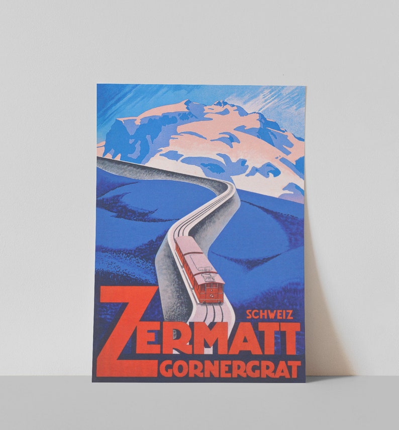 May include: Vintage travel poster featuring a red train ascending a winding track towards a snow-capped mountain. The poster has a blue and white color scheme with the words "Zermatt Gornergrat" in red.