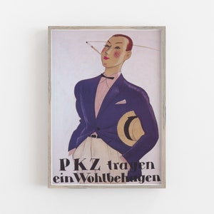 May include: Framed vintage poster featuring a stylized illustration of a person in a dark blue suit, pink shirt, and bow tie, holding a straw hat. The poster has the text "PKZ tragen ein Wohlbehagen" in black letters.