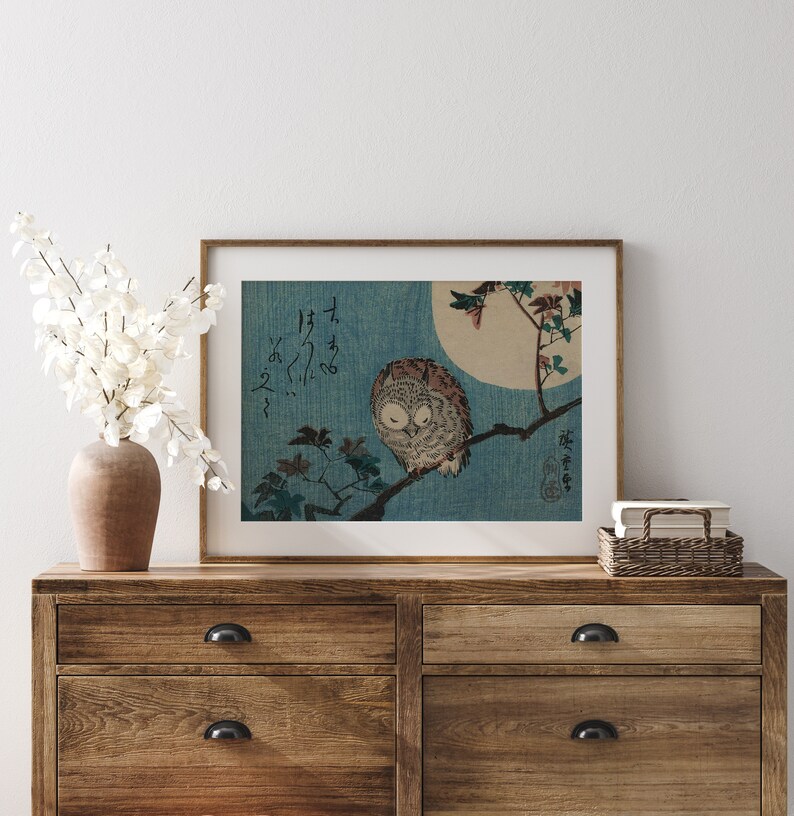 May include: A framed print of a Japanese woodblock print depicting an owl perched on a branch with a full moon in the background. The print is in shades of blue, white, and brown. The Japanese text in the print reads "Fukuro no zu".