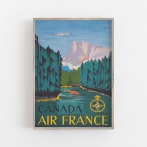 May include: Vintage travel poster featuring a blue and green landscape with a mountain range in the background. A white airplane flies over the trees. The text "CANADA AIR FRANCE" is in yellow letters on a blue background. A compass with a gold crown is in the bottom right corner.