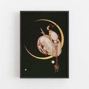 Op de afbeelding: Een ingelijste kunstdruk met een figuur in een wit kledingstuk met textuur en bloemenpatroon, zittend op een grote gouden maansikkel tegen een zwarte achtergrond. Een kleine witte ster is zichtbaar in de linkerbenedenhoek van het beeld.