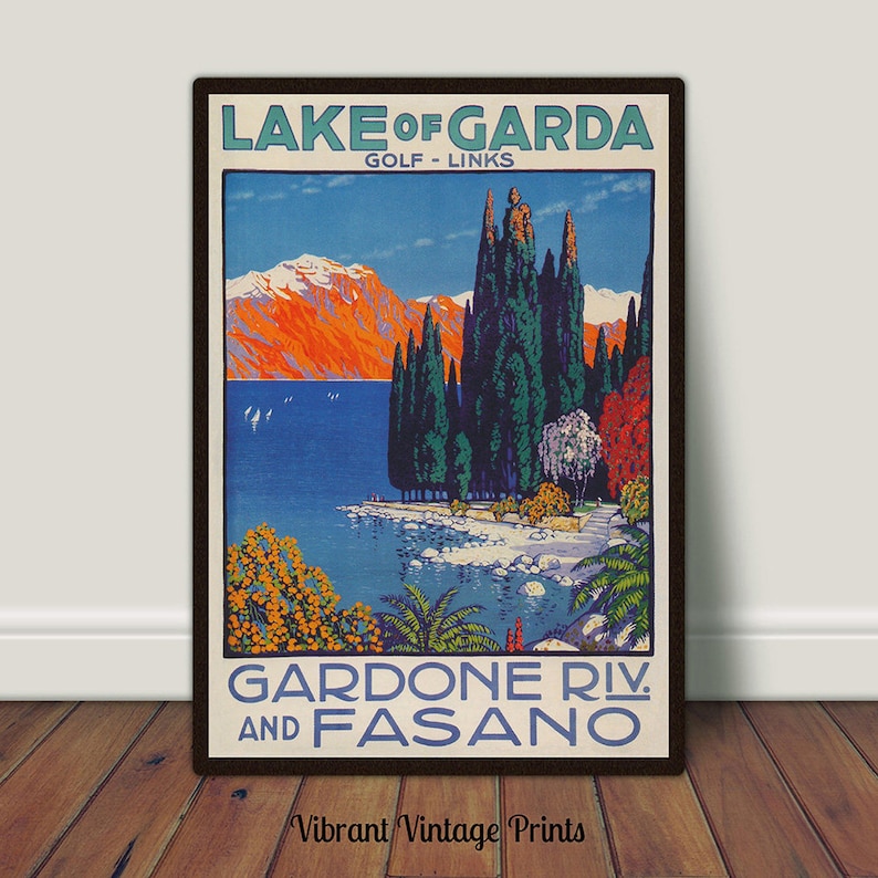 May include: Vintage travel poster for Lake Garda, Italy, featuring a scenic landscape with mountains, tall trees, and a lake. The poster has text that reads "Lake of Garda" and "Gardone Riv. and Fasano."