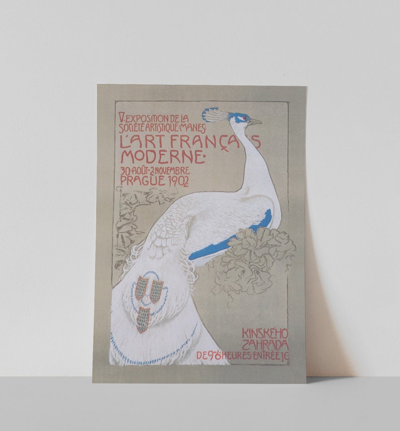 Op de afbeelding: Vintage poster met een illustratie van een witte pauw met blauwe accenten. De poster heeft rode en zwarte tekst, waaronder "L'ART FRAN&Ccedil;AS MODERNE" en data. De achtergrond is een gedempt grijs. Het is een kunsttentoonstelling.