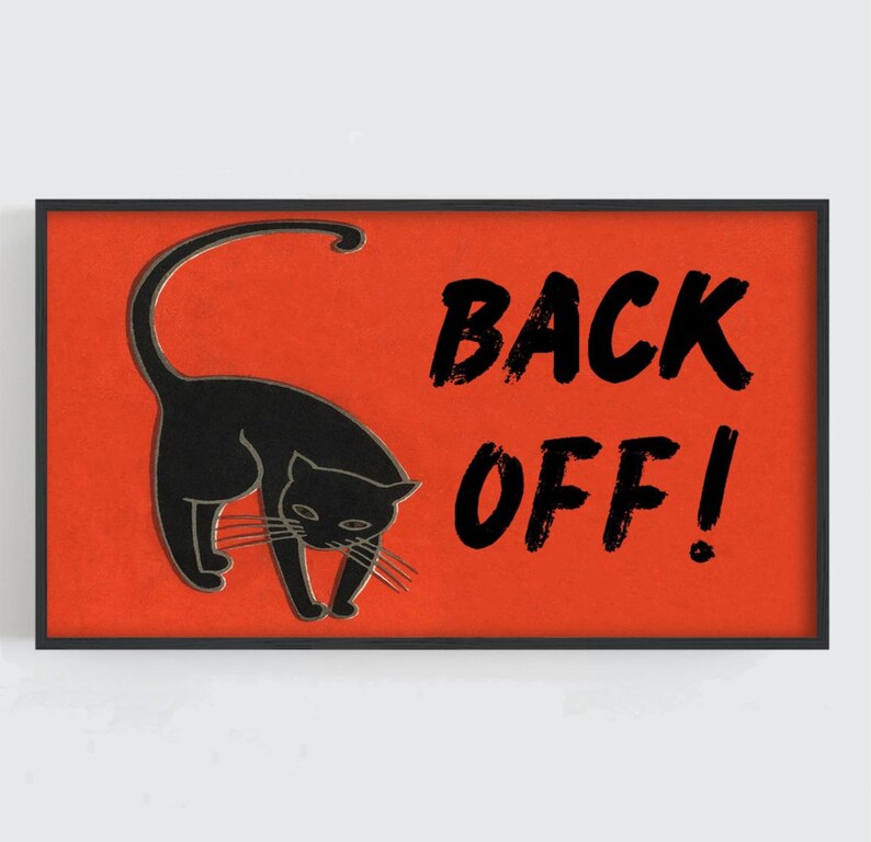 May include: A framed art print featuring a black cat silhouette on a vibrant orange background. Bold black text reads "BACK OFF!" The artwork has a vintage, slightly distressed aesthetic, perfect for adding a touch of humor to any space.