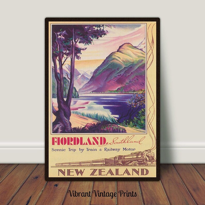 Puede incluir: P&oacute;ster de viaje vintage enmarcado para Fiordland, Nueva Zelanda. El p&oacute;ster representa un paisaje pintoresco con monta&ntilde;as, un lago y un tren. El texto dice "FIORDLAND, Southland" y "NEW ZEALAND". Las palabras "Vibrant Vintage Prints" est&aacute;n en la parte inferior.