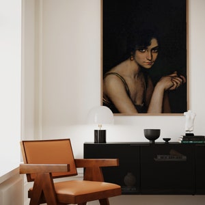 Pode incluir: Uma sala de estar de estilo moderno de meados do s&eacute;culo com um arm&aacute;rio preto, uma cadeira de madeira com estofamento laranja, uma l&acirc;mpada branca e uma pintura emoldurada de uma mulher com cabelo escuro e um vestido verde.