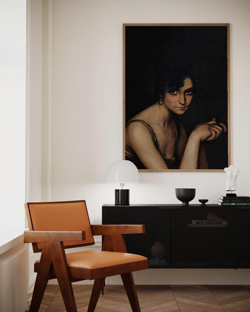 Pode incluir: Uma sala de estar de estilo moderno de meados do s&eacute;culo com um arm&aacute;rio preto, uma cadeira de madeira com estofamento laranja, uma l&acirc;mpada branca e uma pintura emoldurada de uma mulher com cabelo escuro e um vestido verde.