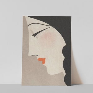 May include: Art Deco style print featuring a woman's profile. The illustration has a black head covering, black hair, and a pale face with a touch of blush and red lips. The background is a muted gray.
