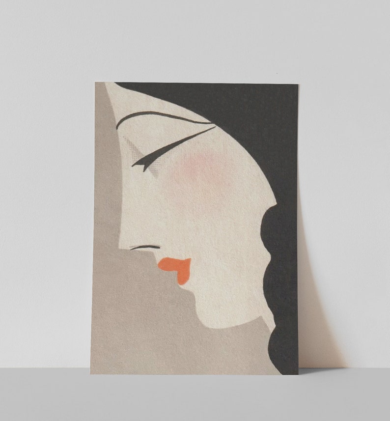 May include: Art Deco style print featuring a woman's profile. The illustration has a black head covering, black hair, and a pale face with a touch of blush and red lips. The background is a muted gray.