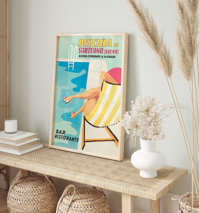 K&ouml;nnte beinhalten: Ein Vintage-Poster, das ein Schwimmbad in Italien bewirbt. Das Poster zeigt eine Frau in einem gelben und wei&szlig;en gestreiften Liegestuhl, mit dem Text "PISCINA DI SARTEANO (SIENA) ACQUA CORRENTE A 24 GRADI BAR RISTORANTE" in einer bunten Schrift.