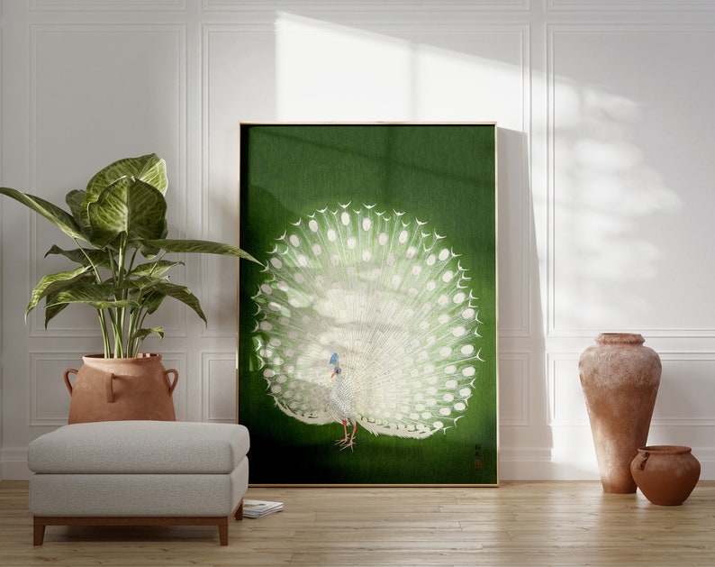 Op de afbeelding: Een ingelijste print van een witte pauw met zijn staartveren uitgespreid in een waaier. De pauw staat op een groene achtergrond.
