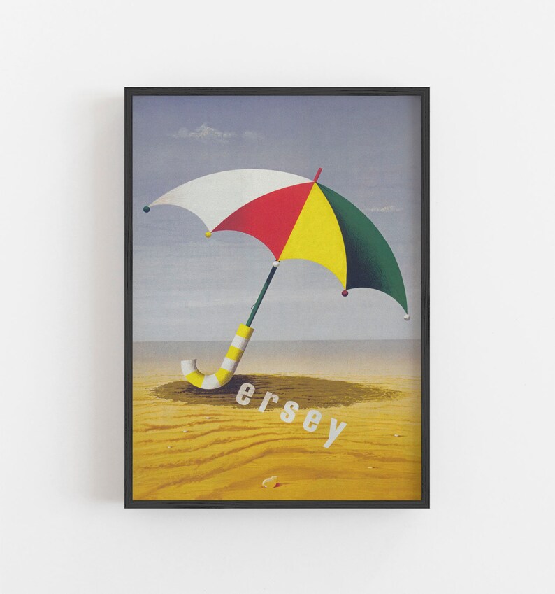 May include: Framed print of a beach scene with a colourful umbrella. The umbrella has white, red, yellow, and green panels. The word "Jersey" is printed in white on the sand. The image is framed in black.
