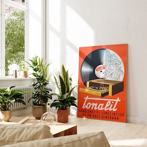 May include: A vintage orange and yellow poster advertising a record player called "Tonalit". The poster features a black vinyl record with a band playing on it. The text on the poster reads "Tonalit,  Hanglamez &eacute;s Lemezj&aacute;tsz&oacute; az &Ouml;n H&aacute;z Zenekara".