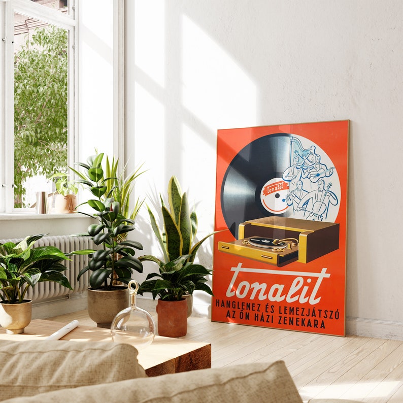 May include: A vintage orange and yellow poster advertising a record player called "Tonalit". The poster features a black vinyl record with a band playing on it. The text on the poster reads "Tonalit,  Hanglamez &eacute;s Lemezj&aacute;tsz&oacute; az &Ouml;n H&aacute;z Zenekara".