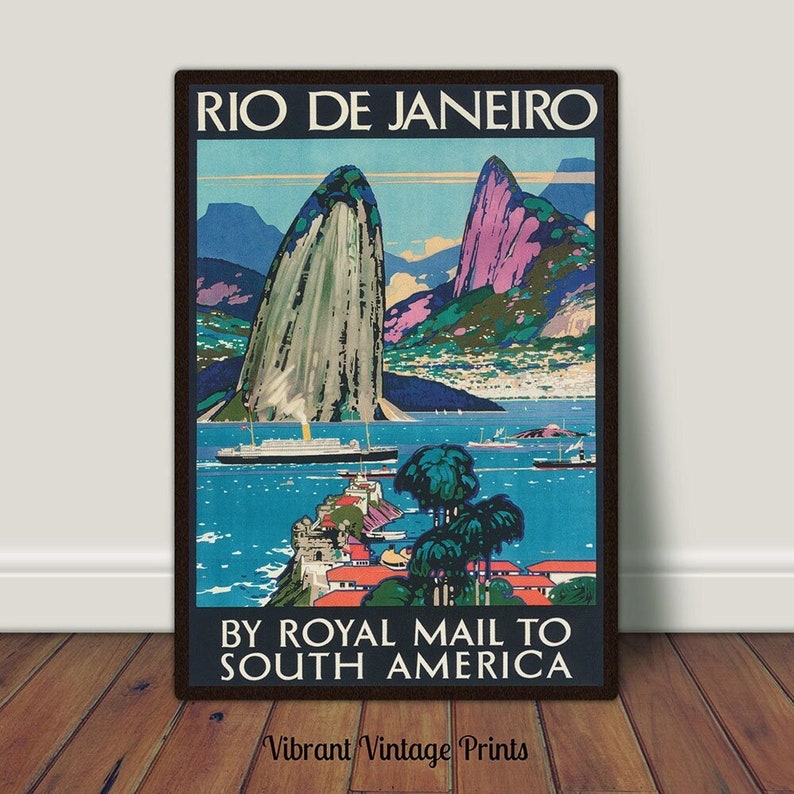 May include: Vintage travel poster advertising a trip to Rio de Janeiro by Royal Mail to South America. The poster features a colorful illustration of Sugarloaf Mountain and Guanabara Bay with ships in the water.