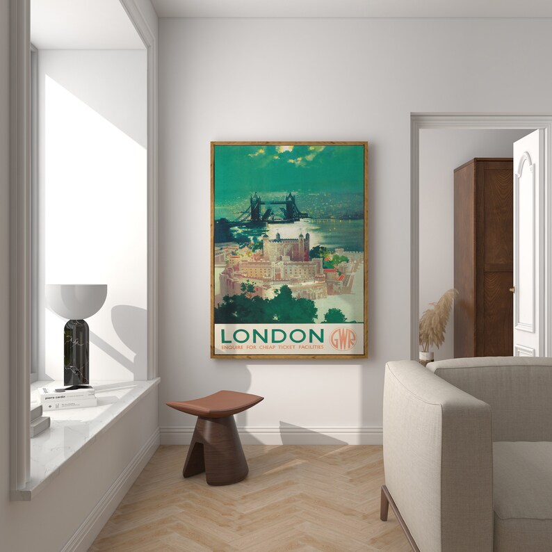 May include: A vintage travel poster featuring a scenic view of the Tower Bridge in London, England. The poster is in a wooden frame and has a green background with the text "LONDON GWR ENQUIRE FOR CHEAP TICKET FACILITIES".