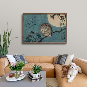 May include: A framed print of a Japanese woodblock print depicting an owl perched on a branch with a full moon in the background. The print is in shades of blue, green, and brown. The Japanese text in the print reads "I hear the owl's cry."