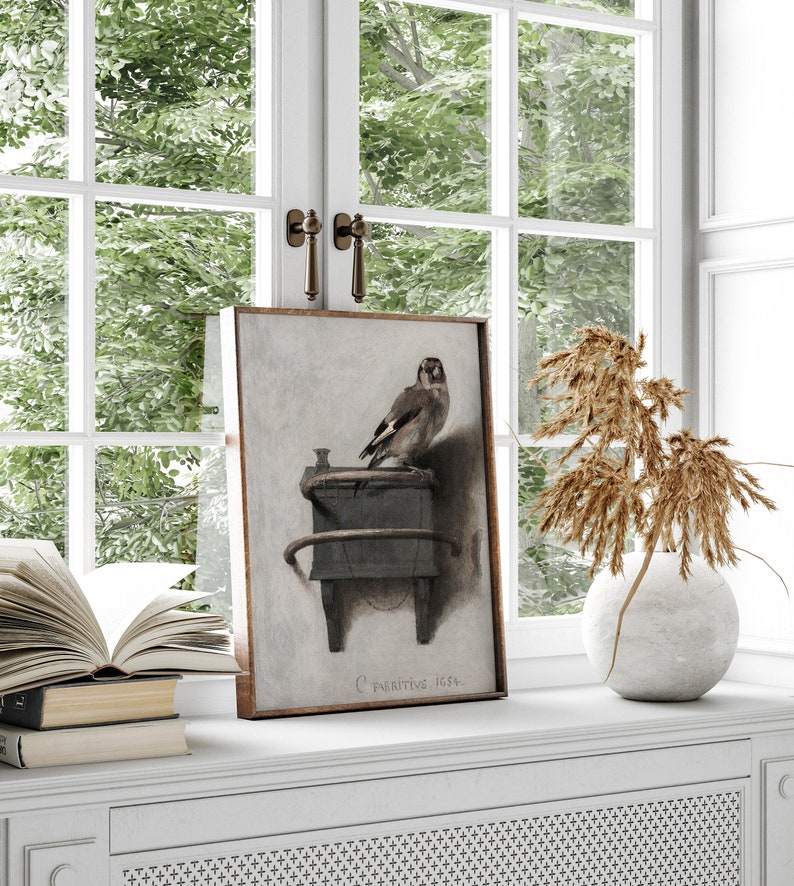 May include: A framed painting of a bird perched on a wooden object. The painting is in a brown frame and has a white background. The bird is brown and white and has a long tail. The painting is titled "C. Fabritius 1654".