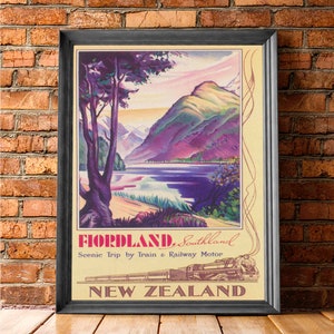Puede incluir: P&oacute;ster de viaje vintage enmarcado para Fiordland, Southland, Nueva Zelanda. La obra de arte presenta un paisaje esc&eacute;nico con un lago, monta&ntilde;as y un tren. El p&oacute;ster tiene un fondo color crema con el texto "Scenic Trip by Train & Railway Motor."