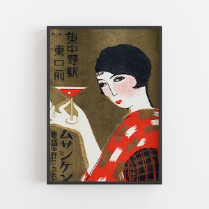 K&ouml;nnte beinhalten: Vintage japanischer Kunstdruck mit einer Frau in einem roten und schwarzen Kimono, die einen Cocktail h&auml;lt. Das Kunstwerk hat einen goldenen Hintergrund und enth&auml;lt japanischen Text. Die Frau hat rote Lippen und einen Bob-Haarschnitt. Der Druck ist in einem schwarzen Rahmen gerahmt.