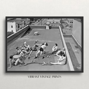 Puede incluir: Impresi&oacute;n vintage en blanco y negro enmarcada que muestra a mujeres en una azotea, algunas boxeando, otras relaj&aacute;ndose. La impresi&oacute;n incluye el texto "VIBRANT VINTAGE PRINTS" en la parte inferior. Se ven edificios al fondo.