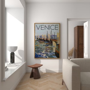 May include: A framed Venice travel poster featuring gondolas on the water. The poster has a vintage aesthetic with the word "VENICE" at the top. The artwork is in a room with a window, a stool, and a sofa.