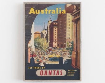 May include: Vintage travel poster advertising a trip to Australia with Qantas Airlines. The poster features a colorful illustration of a city street with buildings and people, and the text "Australia" in yellow letters.