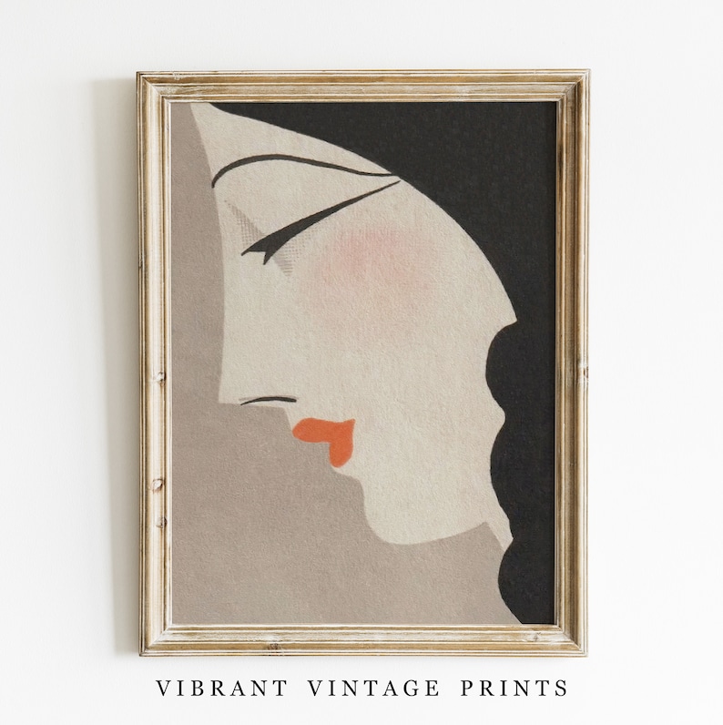 May include: A framed vintage art print featuring a stylized profile of a woman. The artwork has a muted color palette with a peach complexion, red lips, and black hair. The print is in a gold-colored frame, and the text "VIBRANT VINTAGE PRINTS" is at the bottom.