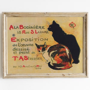 May include: Framed vintage poster featuring two cats, one black and one calico, with text in red and green. The poster advertises an exhibition of work by T.A. Steinlen, with the dates April 10 to May 15, 1894.