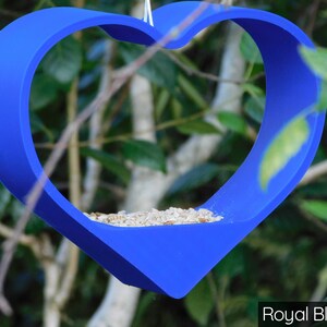May include: A royal blue heart-shaped bird feeder with birdseed inside.