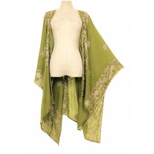 May include: A flowing, olive green kimono-style garment with intricate floral embroidery in a lighter shade. The open-front design drapes elegantly, showcasing the detailed patterns along the edges and sleeves. The garment is displayed on a mannequin.