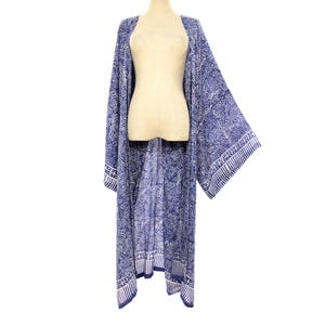 May include: A blue and white patterned kimono-style robe. The robe features a floral design and a border pattern along the edges. The garment is displayed on a mannequin against a white background. The robe is a lightweight, flowing garment.