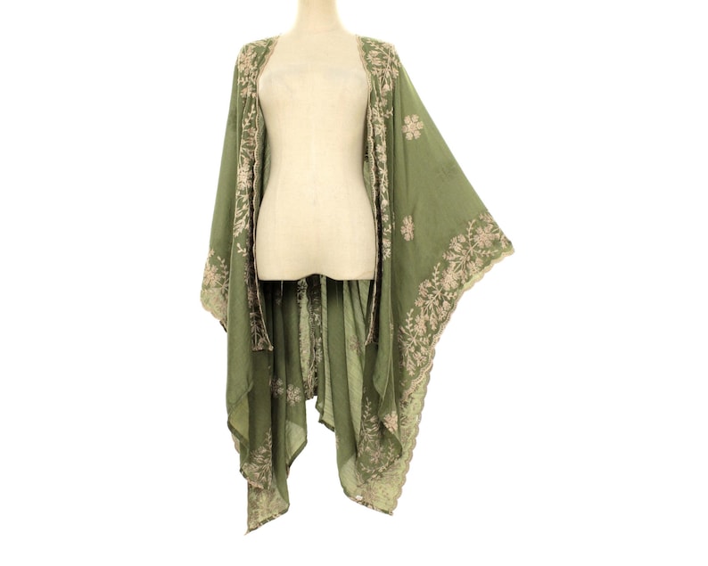 May include: Olive green kimono-style cover-up with floral embroidery. The open-front garment features long sleeves and a flowing silhouette. The embroidery is in a contrasting light beige color, adding detail to the lightweight fabric.