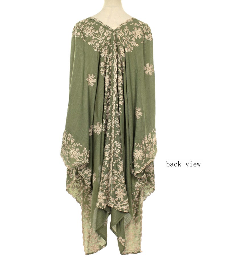 May include: Olive green embroidered tunic with a flowing silhouette. The tunic features intricate floral embroidery in a contrasting beige color along the edges, sleeves, and center panel. The back view is shown, highlighting the design details.