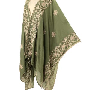 May include: Olive green embroidered shawl with floral and leaf patterns. The shawl features a scalloped edge and intricate beige embroidery along the borders and neckline. The lightweight fabric drapes elegantly, showcasing the detailed design.